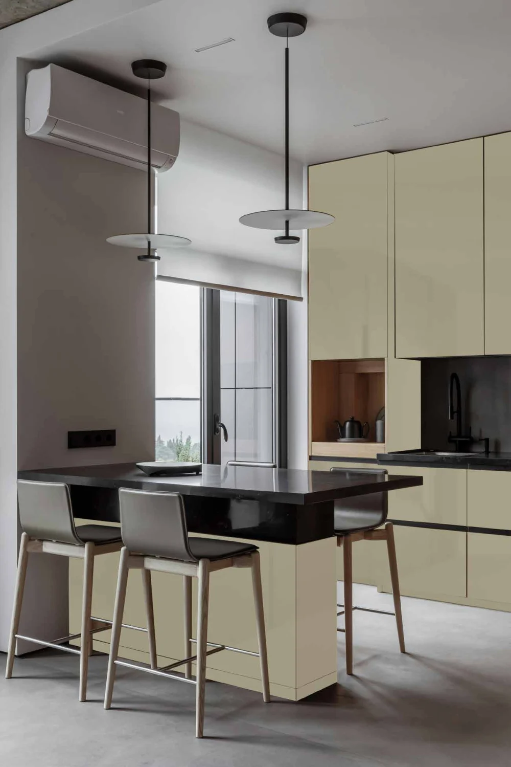 Khaki matte cabinets and a breakfast island beside a daylight window.
