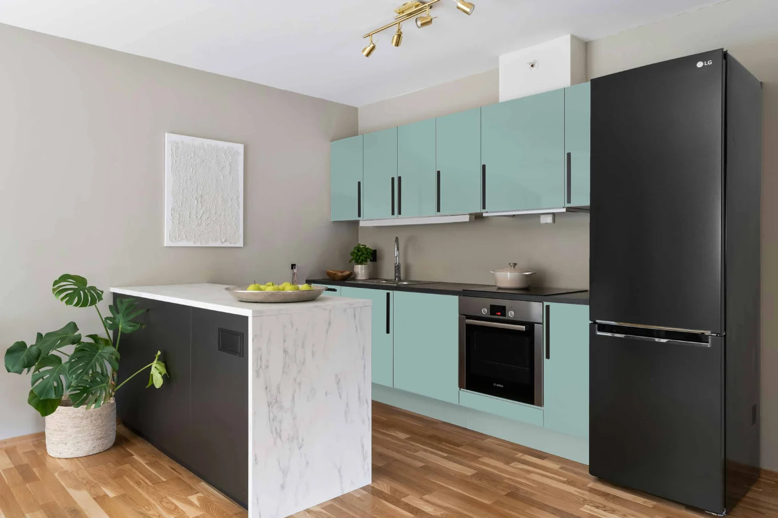 Blue matte kitchen cabinets with dark handles and a light island.